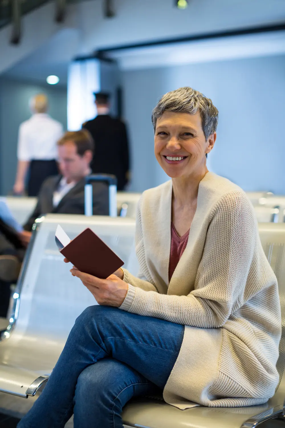 Viajante sorrindo com o passaporte na mão na sala de embarque do aeroporto